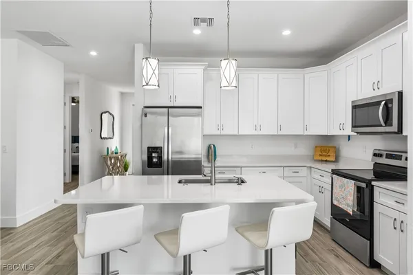 a kitchen with stainless steel appliances a sink a stove a refrigerator and cabinets