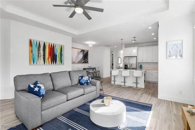 a living room with furniture and a view of kitchen