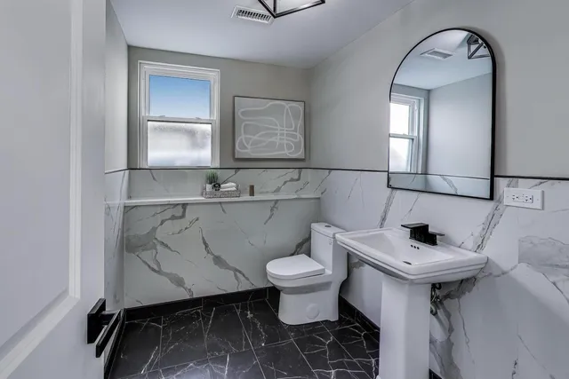 a bathroom with a sink toilet and mirror