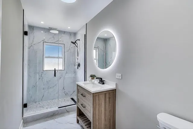 a bathroom with a sink mirror vanity and toilet