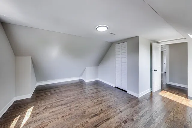 an empty room with wooden floor & windows & ceiling fan