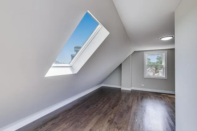 an empty room with wooden floor and entryway