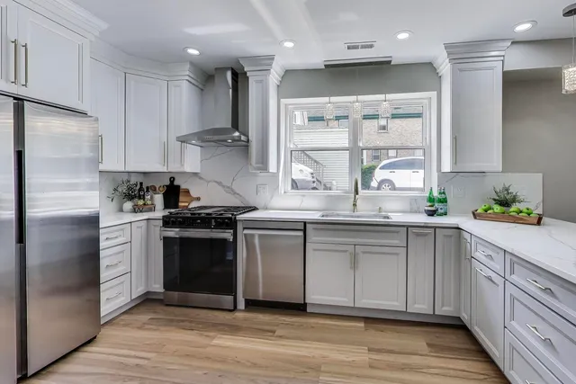 a kitchen with granite countertop a sink stainless steel appliances and cabinets