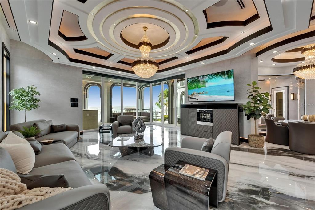 6526 Surfside Boulevard Apollo Beach, FL 33572 - Photo 32 of 99 a living room with furniture a fireplace and a chandelier