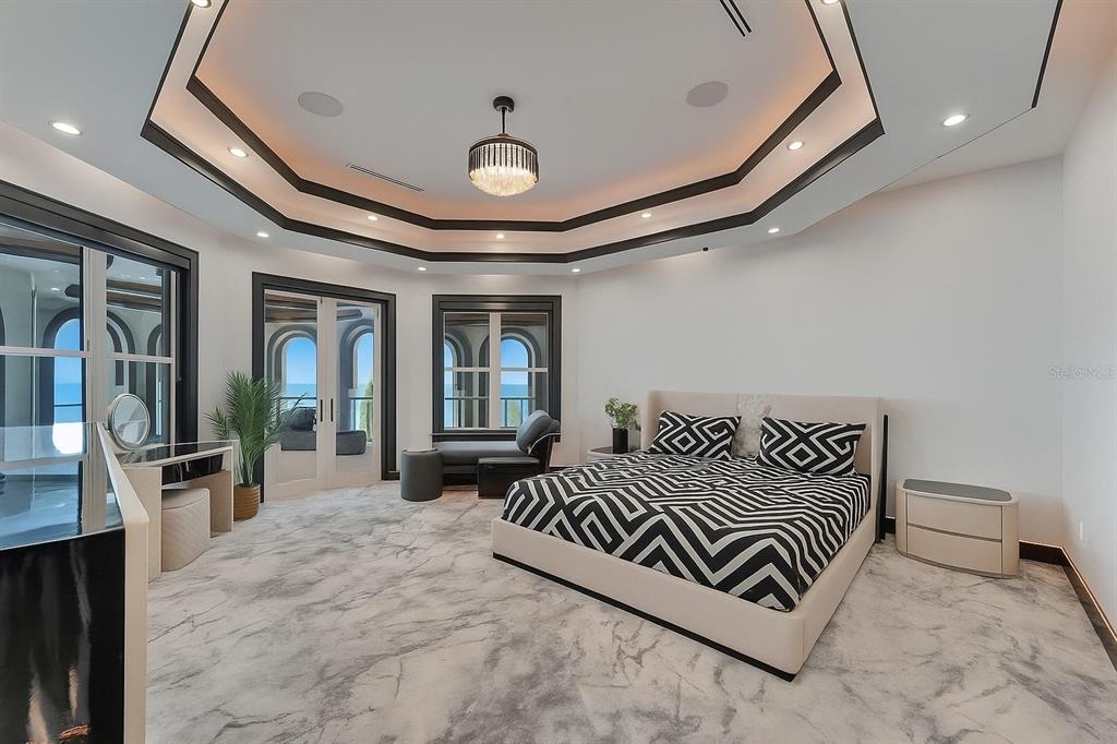 6526 Surfside Boulevard Apollo Beach, FL 33572 - Photo 61 of 99 a bedroom with a large bed and a chandelier