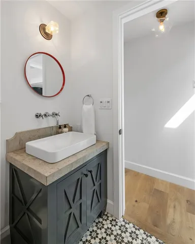 a bathroom with a granite countertop sink a mirror and a toilet