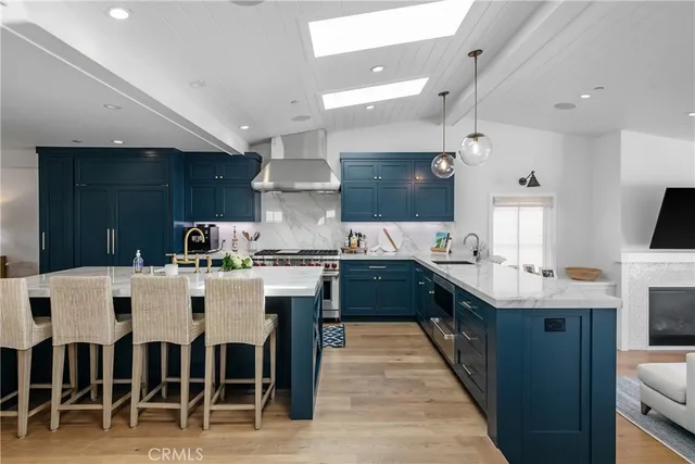a kitchen with stainless steel appliances kitchen island granite countertop a table chairs sink and cabinets