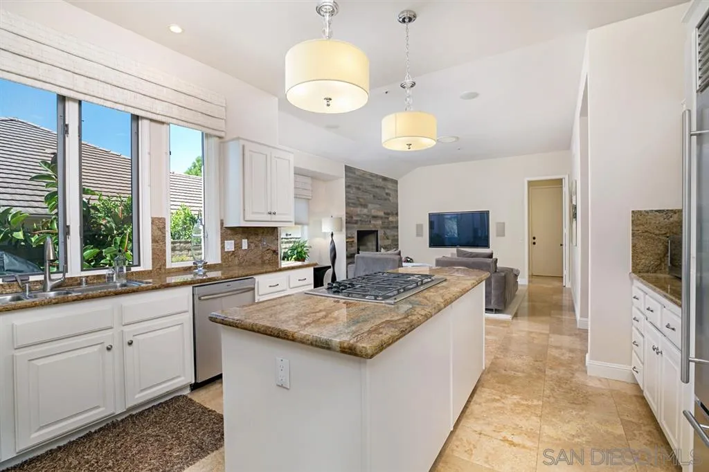 14150 Steeple Chase Row San Diego, CA 92130 - Photo 11 of 25 a large kitchen with kitchen island granite countertop a sink and a stove top oven