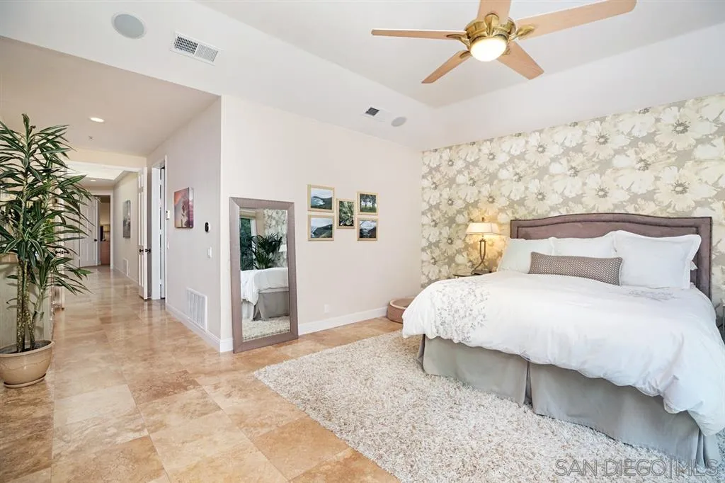 14150 Steeple Chase Row San Diego, CA 92130 - Photo 16 of 25 a bedroom with a large bed and a chandelier