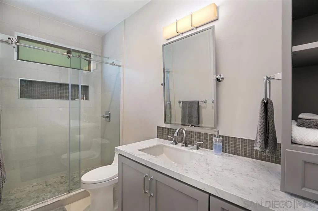 14150 Steeple Chase Row San Diego, CA 92130 - Photo 22 of 25 a bathroom with a granite countertop sink a toilet and shower