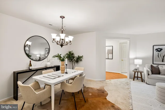 a living room with dining table and a chandelier