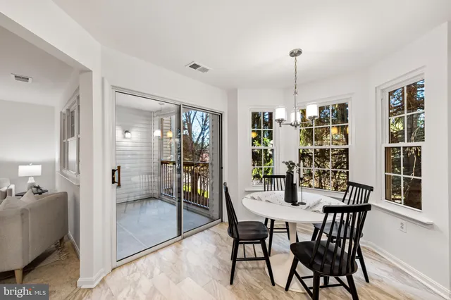 a dining room with furniture a chandelier and wooden floor