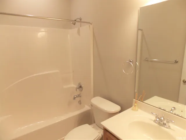 a bathroom with a bathtub shower sink vanity and toilet
