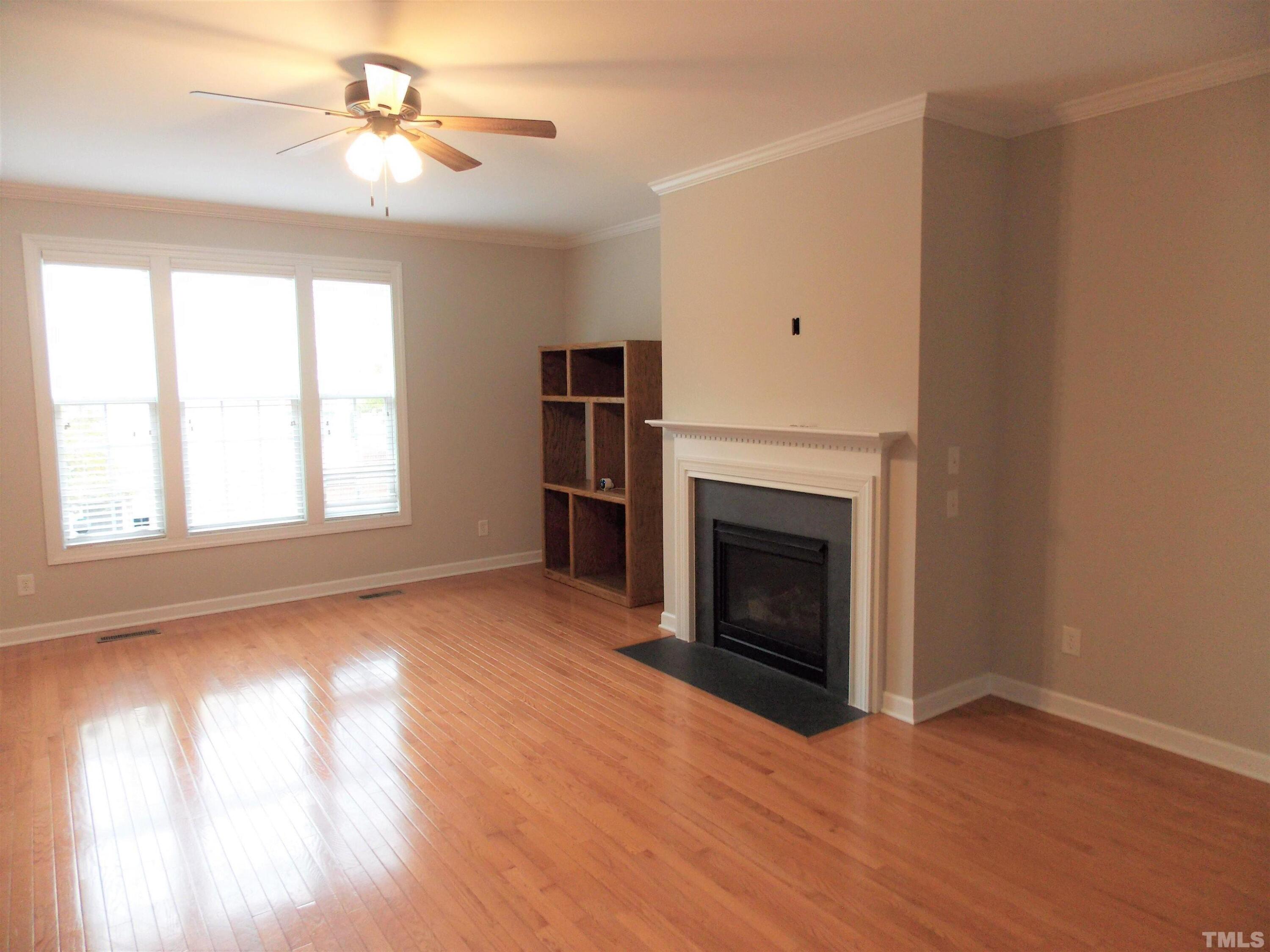4032 Abbey Park Way Raleigh, NC 27612 - Photo 3 of 35 a view of empty room with a fireplace and wooden floor