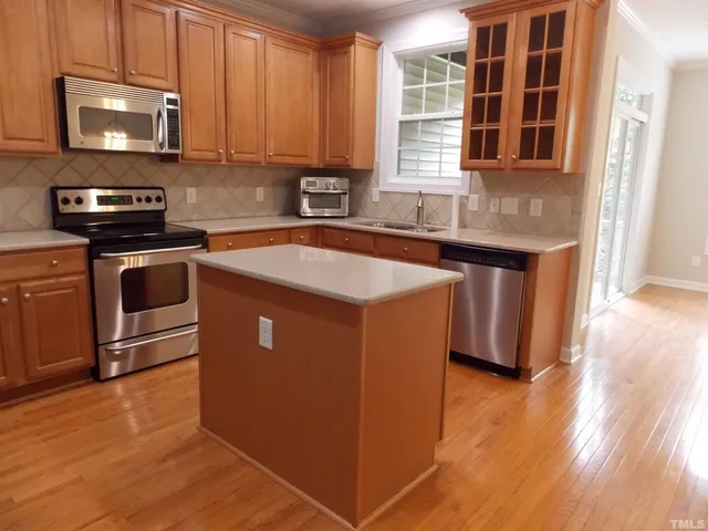 a kitchen with stainless steel appliances granite countertop a stove a sink and a microwave