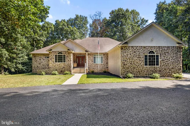 a view of a house with a yard and a large tree