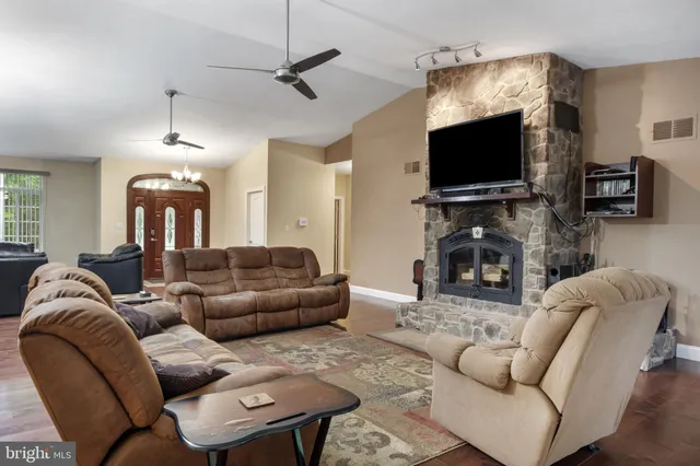 a view of a hallway with wooden floor and a bathroom