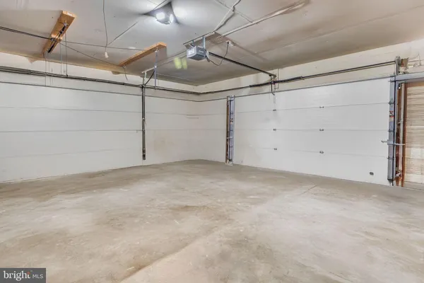 a kitchen with stainless steel appliances kitchen island granite countertop a refrigerator a stove a sink and white cabinets with wooden floor