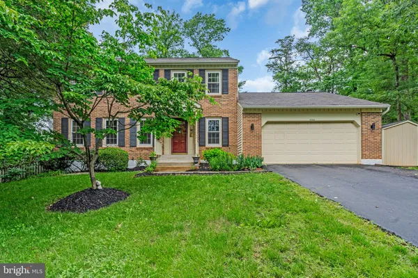 a view of a brick house with a yard and plants