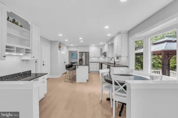 a kitchen with stainless steel appliances granite countertop a kitchen island a stove a table and chairs