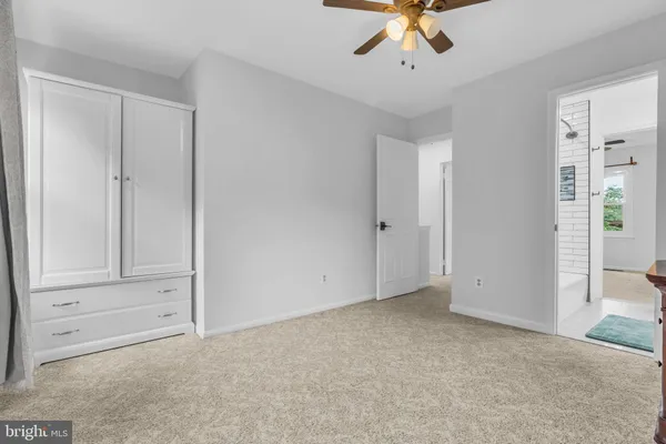 a bedroom with a bed and a chandelier fan