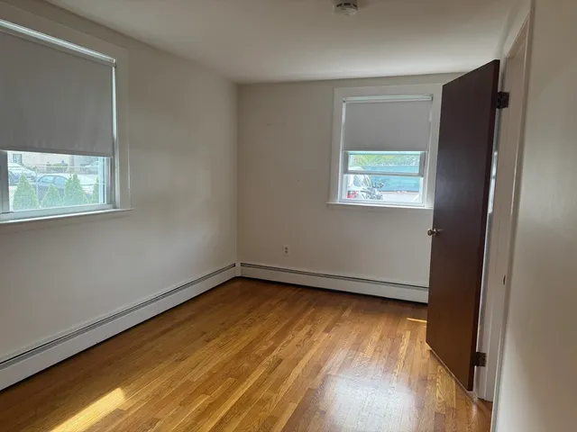 an empty room with wooden floor and a window