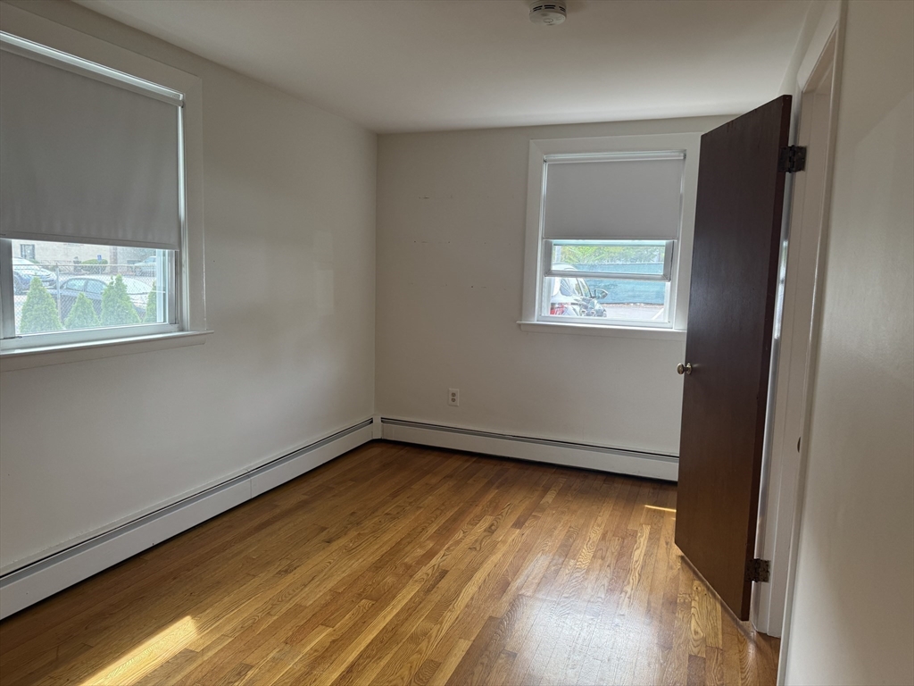 100 Magnolia Avenue, Unit 4 Lynn, MA 01904 - Photo 6 of 19 a view of an empty room with wooden floor and a window
