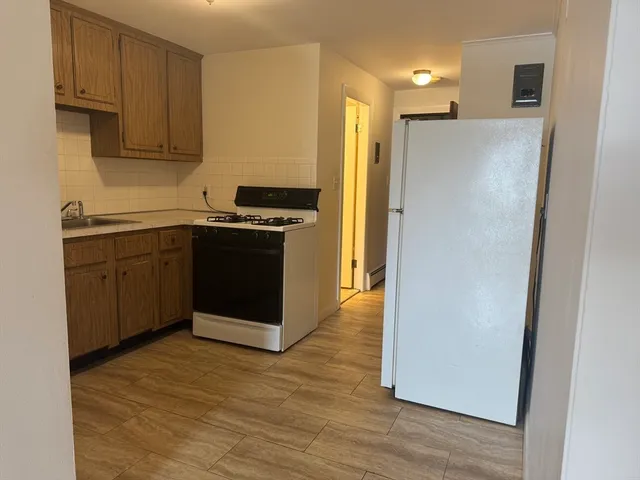 a kitchen with granite countertop a sink stove and cabinets