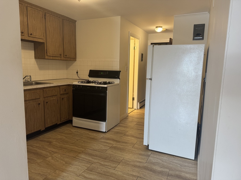 100 Magnolia Avenue, Unit 4 Lynn, MA 01904 - Photo 10 of 19 a kitchen with stainless steel appliances granite countertop a refrigerator and a sink