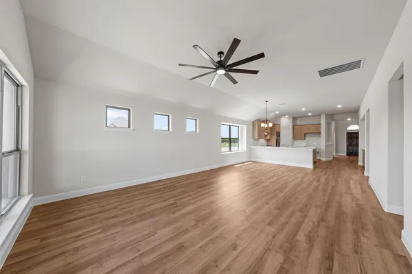 a view of a livingroom with wooden floor and a ceiling fan