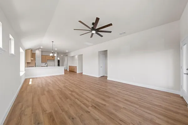 a view of a big room with wooden floor and a ceiling fan