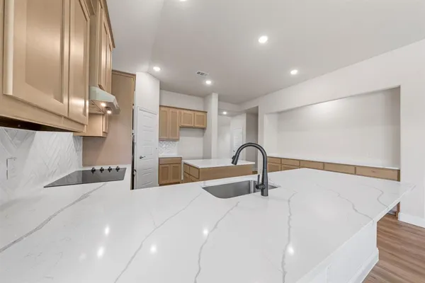 a kitchen with stainless steel appliances a sink and a wooden floor