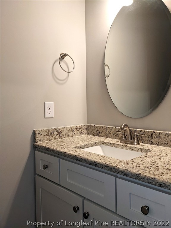 2903 Rockfish Road Raeford, NC 28376 - Photo 13 of 28 a bathroom with a granite countertop sink and a mirror