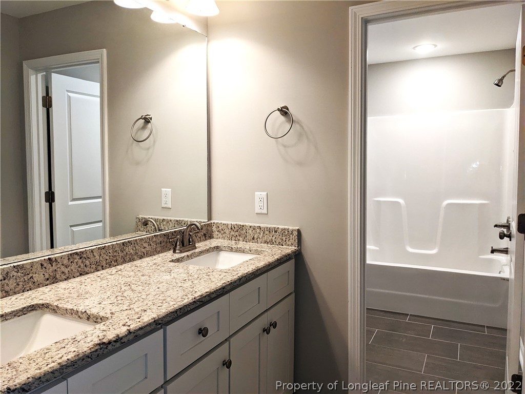 2903 Rockfish Road Raeford, NC 28376 - Photo 19 of 28 a bathroom with a granite countertop sink and a mirror