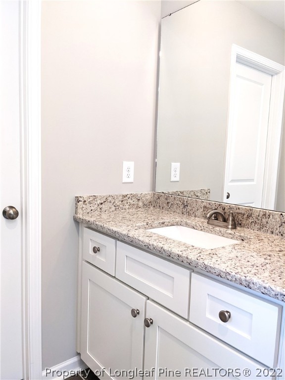 2903 Rockfish Road Raeford, NC 28376 - Photo 25 of 28 a bathroom with a granite countertop sink and a mirror