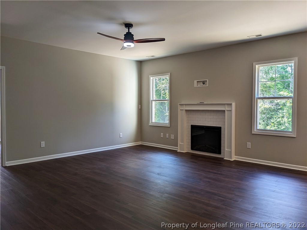 2903 Rockfish Road Raeford, NC 28376 - Photo 5 of 28 a view of an empty room with wooden floor fireplace and a window
