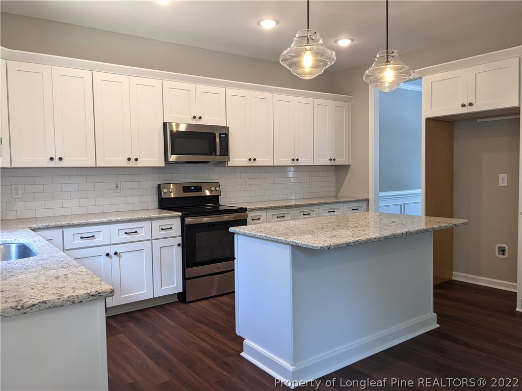 2903 Rockfish Road Raeford, NC 28376 - Photo 8 of 28 a kitchen with granite countertop wooden cabinets and a stove