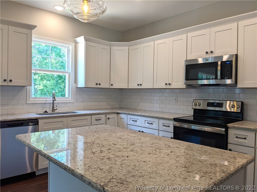 2903 Rockfish Road Raeford, NC 28376 - Photo 9 of 28 a kitchen with stainless steel appliances granite countertop a sink a stove and microwave