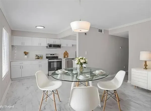 a kitchen with stainless steel appliances a dining table and chairs
