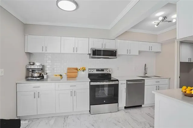 a kitchen with white cabinets and stainless steel appliances