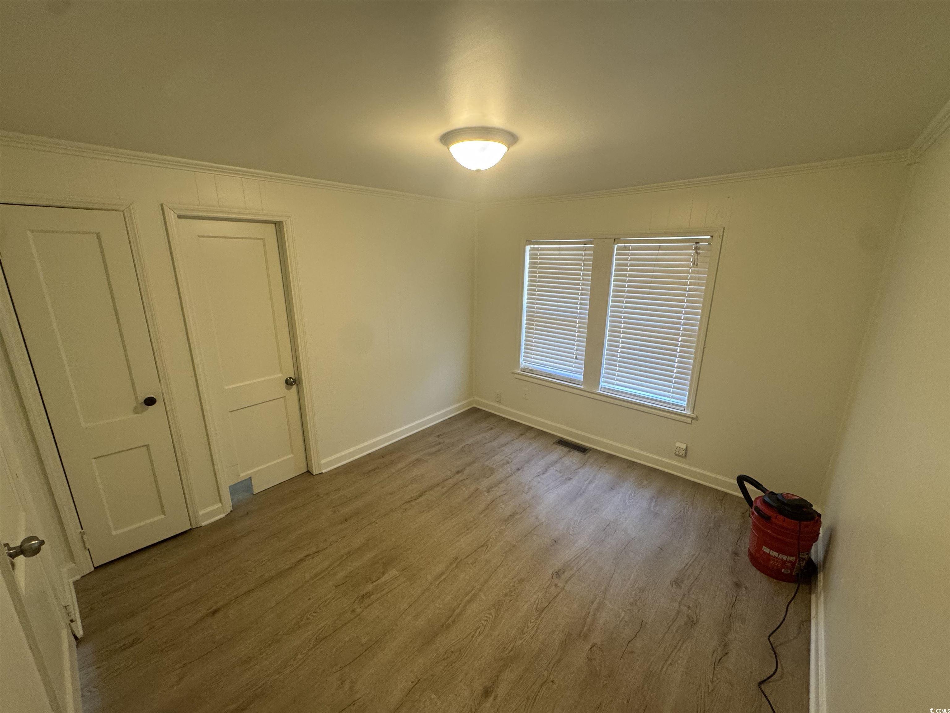 5724 Norton Road Green Sea, SC 29545 - Photo 13 of 20 Empty room featuring wood finished floors and crown molding