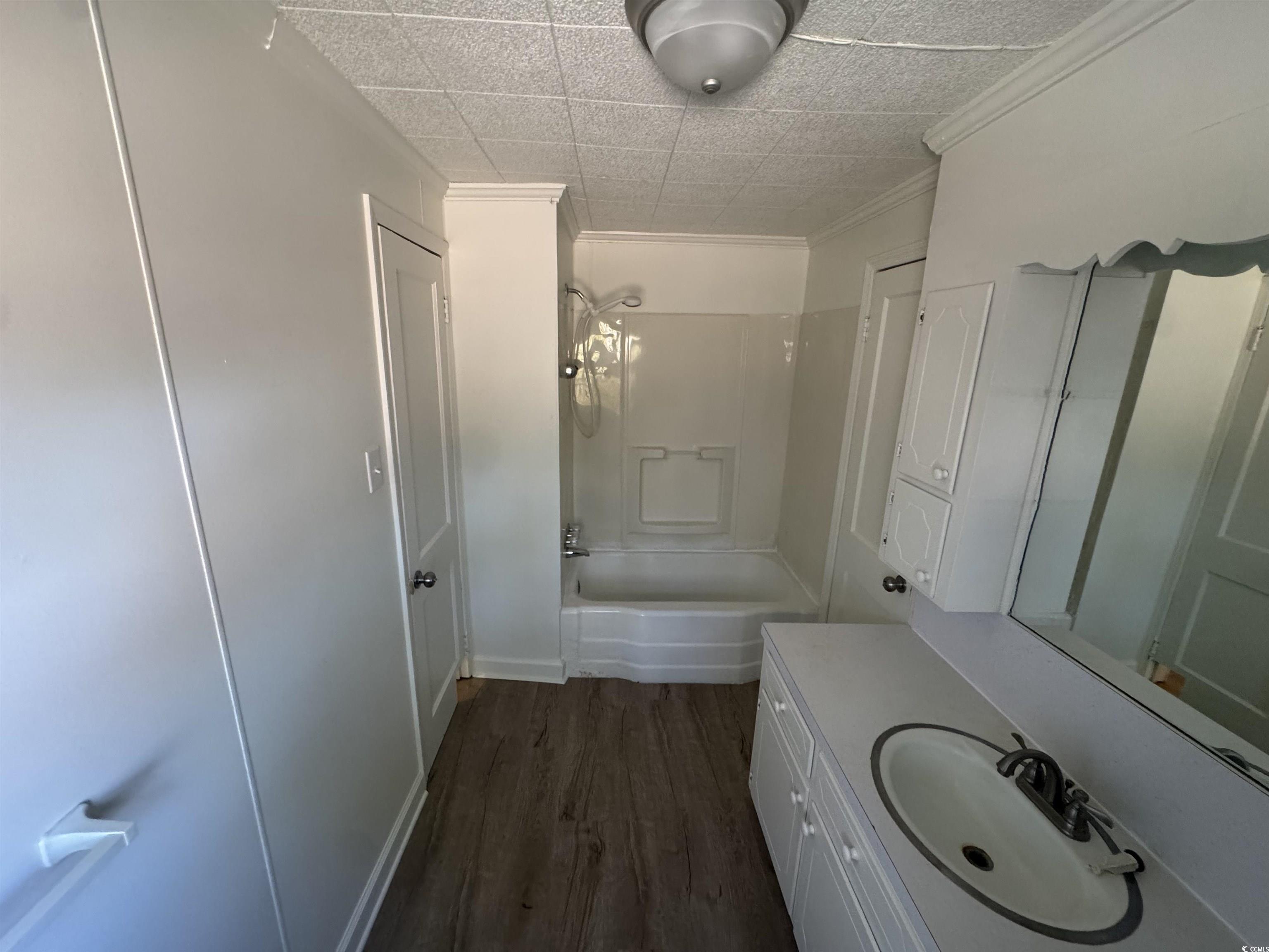 5724 Norton Road Green Sea, SC 29545 - Photo 15 of 20 Full bathroom with dark wood finished floors, vanity, washtub / shower combination, and crown molding