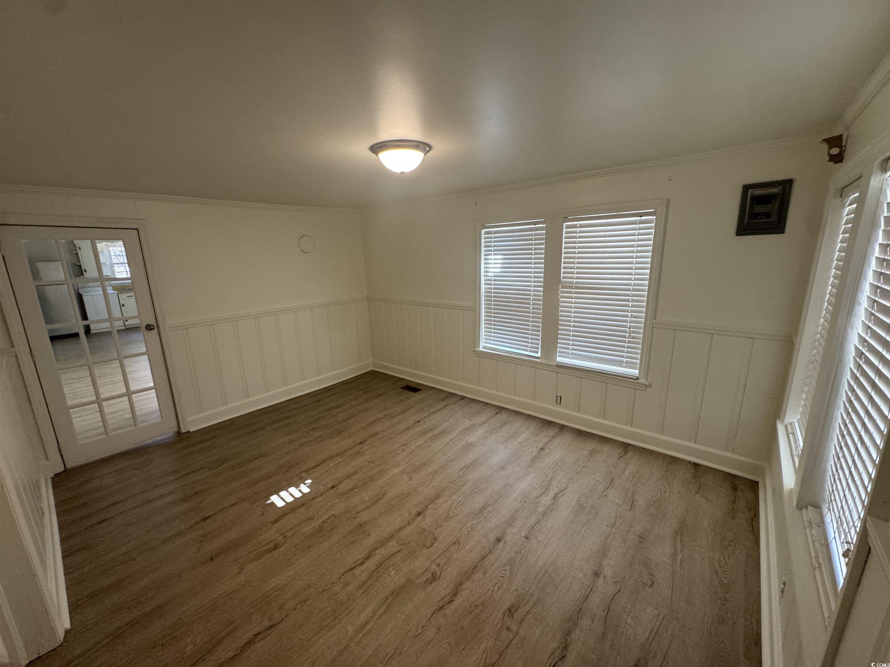 5724 Norton Road Green Sea, SC 29545 - Photo 17 of 20 Unfurnished bedroom featuring wood finished floors, a wainscoted wall, crown molding, and a decorative wall