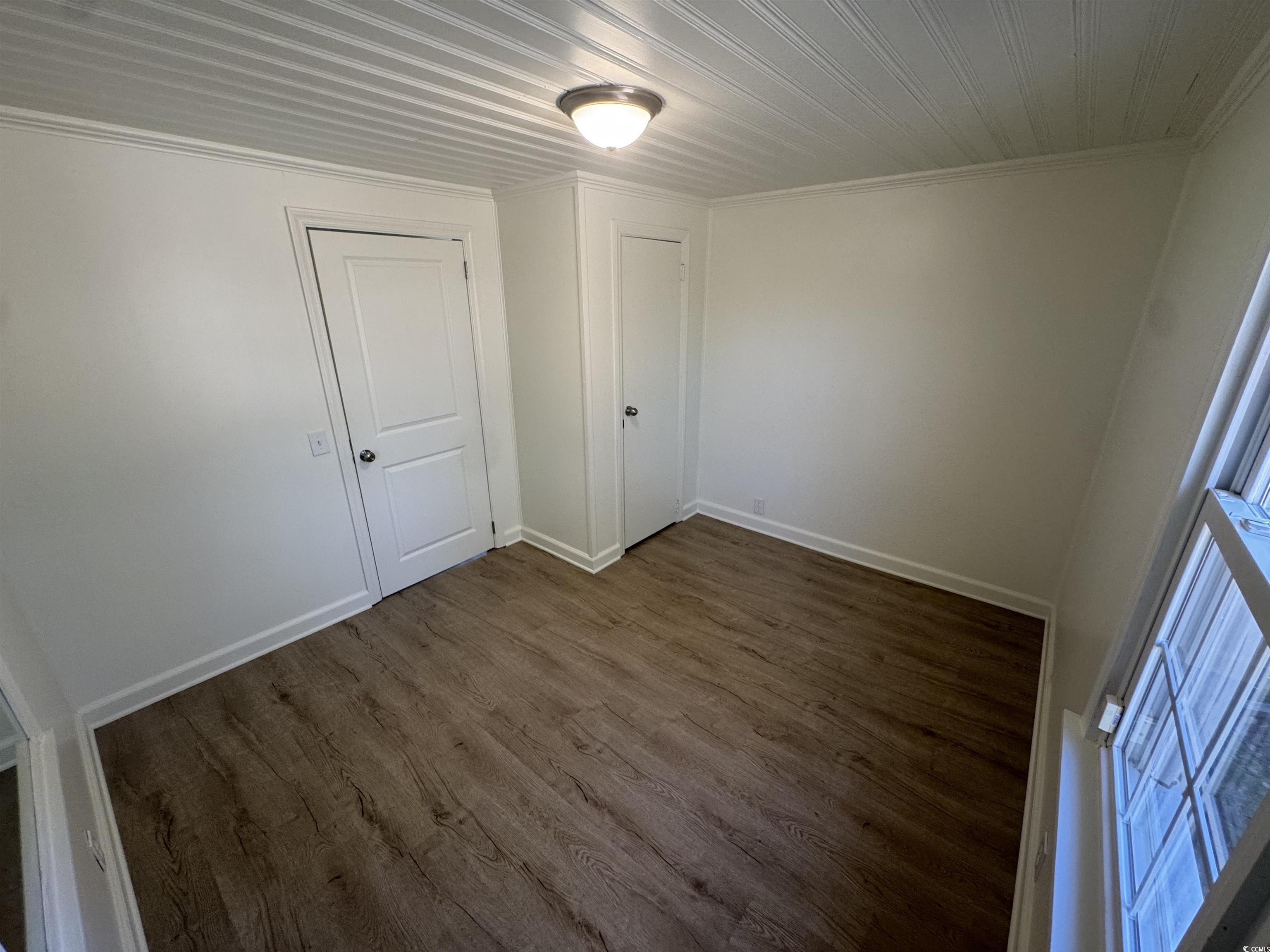 5724 Norton Road Green Sea, SC 29545 - Photo 10 of 20 Unfurnished bedroom with dark wood finished floors, ornamental molding, and a closet