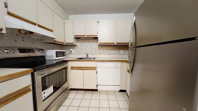 a kitchen with stainless steel appliances a sink stove and cabinets