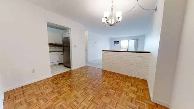 a spacious bedroom with a bed and a chandelier
