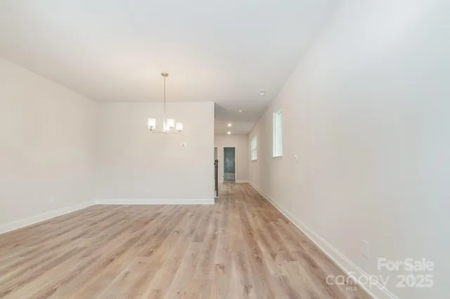 a view of a room with wooden floor and a ceiling fan