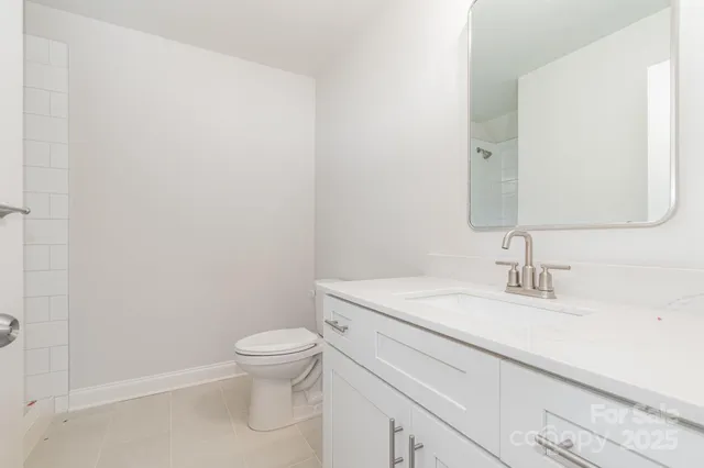 a bathroom with a granite countertop toilet a sink and a mirror