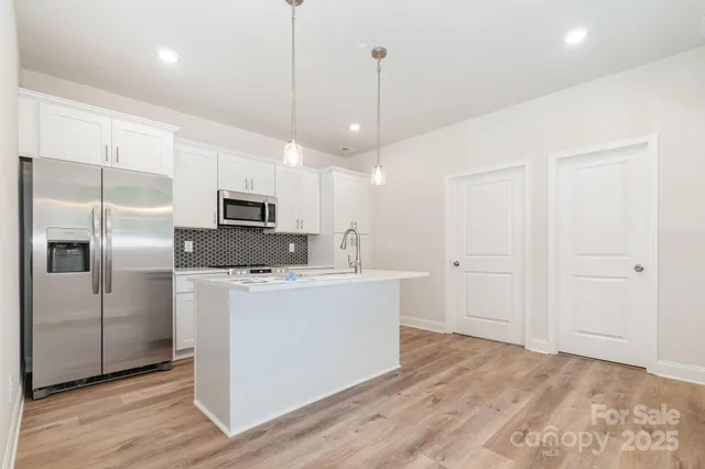 a kitchen with stainless steel appliances a refrigerator sink and microwave