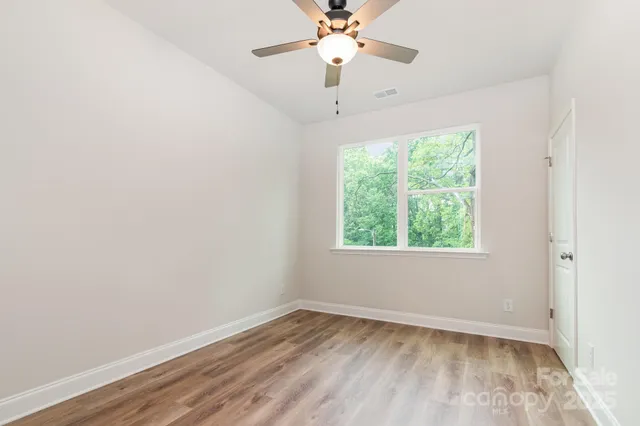 an empty room with a window and wooden floor